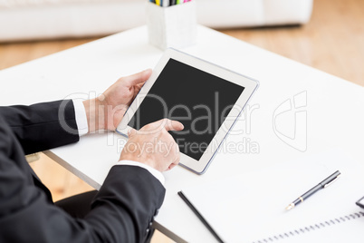 Businessman using digital tablet at desk