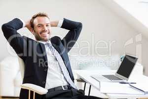 Happy businessman relaxing in office