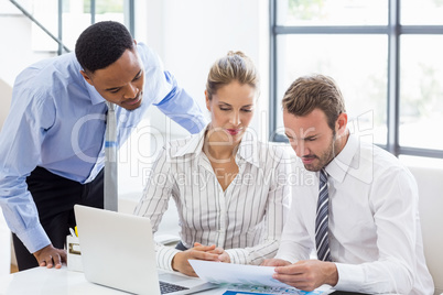 Business colleagues reviewing a report at desk