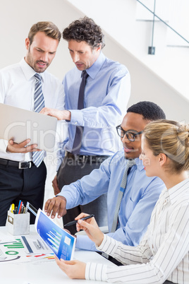 Business colleagues reviewing a report at desk