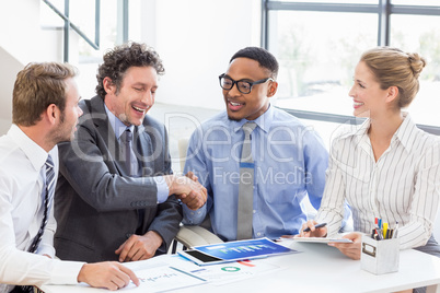 Businessman shaking hands with colleagues in meeting