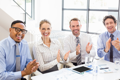 Businesspeople applauding while in a meeting