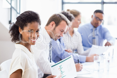 Portrait of businesswoman holding a report at meeting