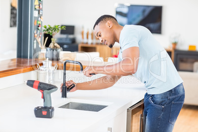 Man tightening tap with a wrench