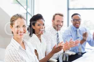 Businesspeople applauding while in a meeting