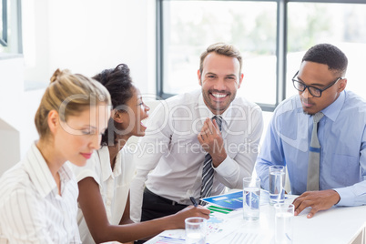 Businesswoman day dreaming while colleague discussing in backgro