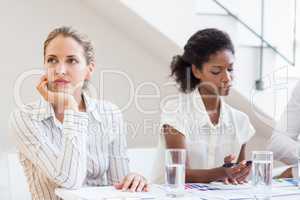 Businesswoman day dreaming while having meeting with colleagues
