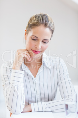 Happy businesswoman sitting with hand on chin