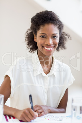 Portrait of businesswoman writing a report