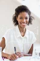 Portrait of businesswoman writing a report
