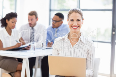 Happy businesswoman using laptop in office