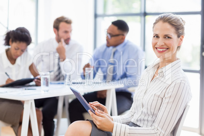 Happy businesswoman using digital tablet in office