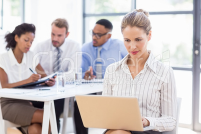 Businesswoman using laptop in office