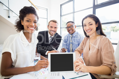 Portrait of businesspeople holding a digital tablet during a mee