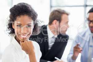 Portrait of businesswoman sitting with hand on chin in office