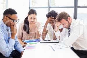 Depressed businesspeople sitting at table during a meeting