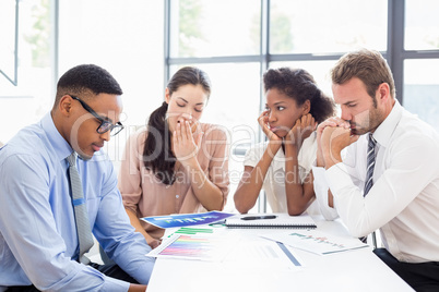 Tensed businesspeople sitting at table during a meeting