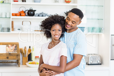 Young couple embracing in kitchen