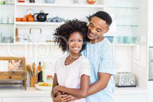 Young couple embracing in kitchen