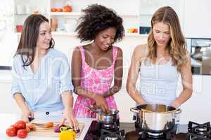 Friends preparing a meal in kitchen