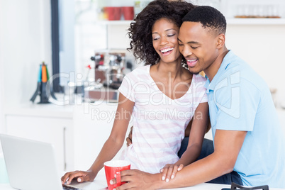 Happy couple using laptop