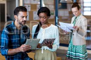 Young man and woman discussing using digital tablet