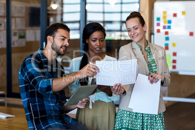 Young man and women discuss using digital tablet and document