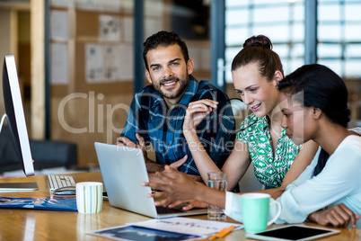 Young man and women sitting at their desk