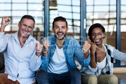 Colleagues cheering with clenched fist Colleagues cheering with clenched fist