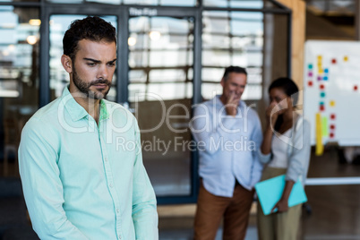 Depressed young man standing in the office