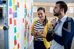 Colleagues looking at white board