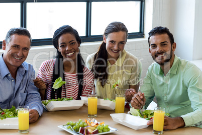 Colleagues having breakfast in office