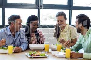 Colleagues having breakfast in office