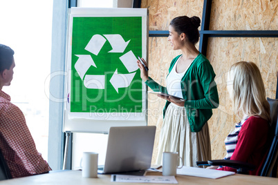 Colleagues discussing with recycling sign on white board