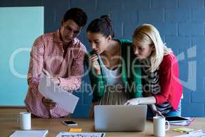 Colleagues discussing at their desk