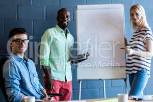 Colleagues standing by white board