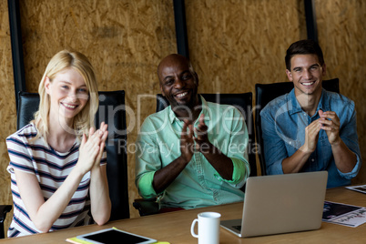 Colleagues applauding at their desk