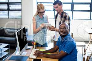 Man working on computer while interacting in the background