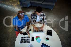 Colleagues using digital tablet and laptop