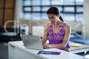 Young woman sitting at desk using laptop