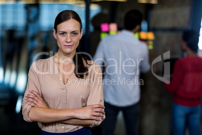 Young woman with arms crossed looking at camera