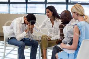 Colleagues comforting a unhappy man