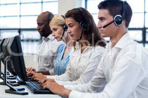 Team of colleagues working on computer with headset