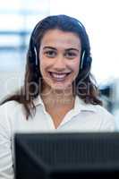 Young woman working on computer with headset