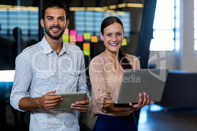 Colleagues holding digital tablet and laptop