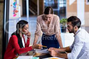 Team of colleagues discussing at their desk