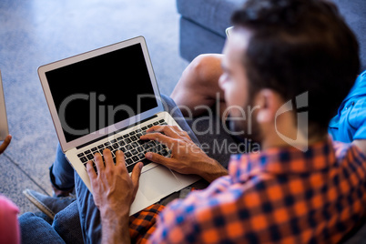 Man siting on sofa using laptop