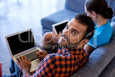 Colleagues siting on sofa using laptop