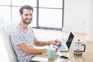 Man smiling at camera while writing notes