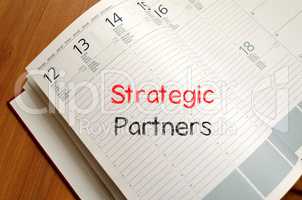 Strategic partners write on notebook